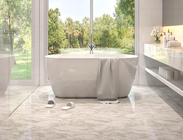 Modern bathroom with a freestanding white soaking tub and polished ceramic floor tile installation overlooking a scenic window view.