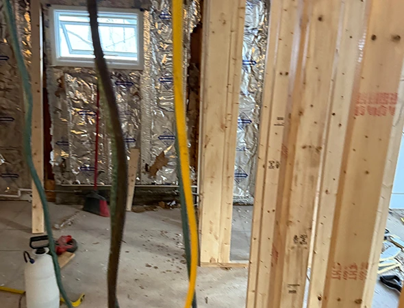 Close-up of residential wall framing and insulation installed by Kennison Construction builders during a home extension.